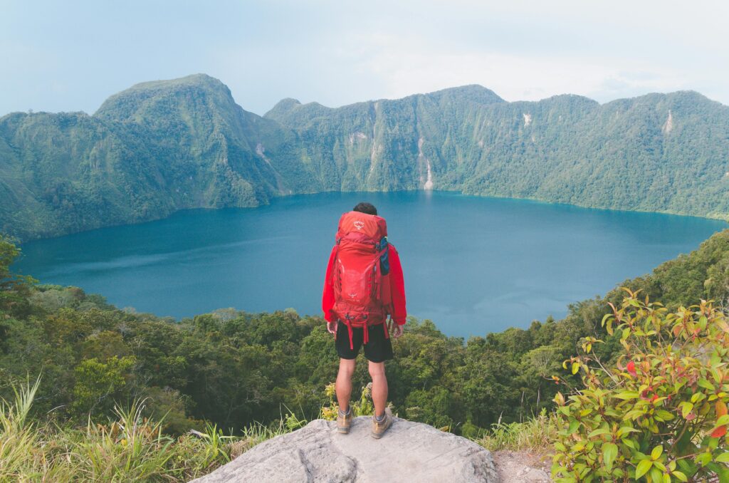 pexels photo 2517748 2517748 Hiker with backpack enjoying scenic mountain lake view on a bright summer day.